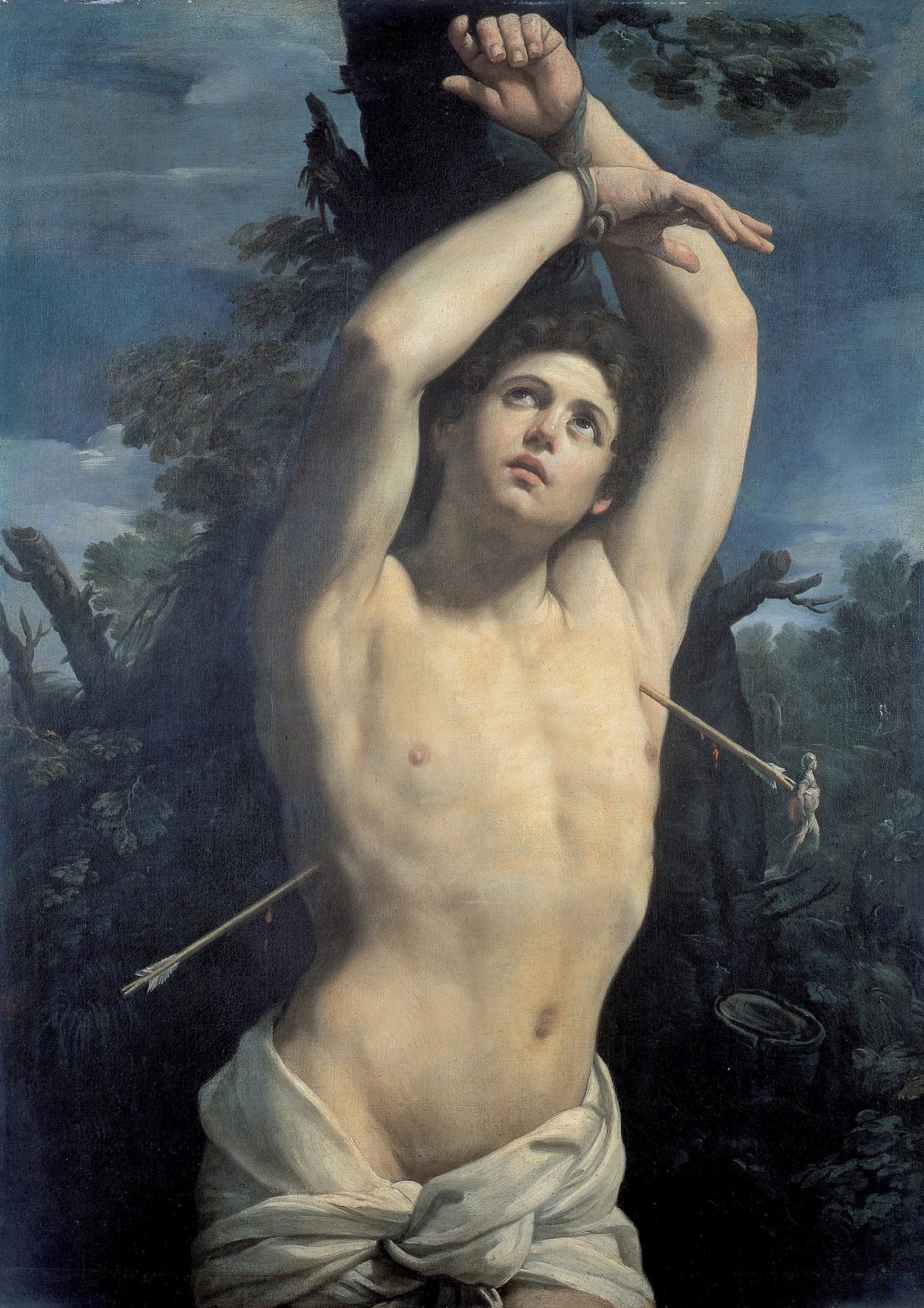 Saint Sebastian by Guido Reni, about 1615, as a framed print in a black frame on a cream wall. A young man with his wrists bound above his head to a tree looks up to the sky, pierced by two arrows, a white cloth at his hips, against blue sky and dark leaves.